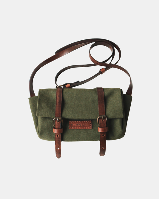 Green bag with brown straps on a light gray background