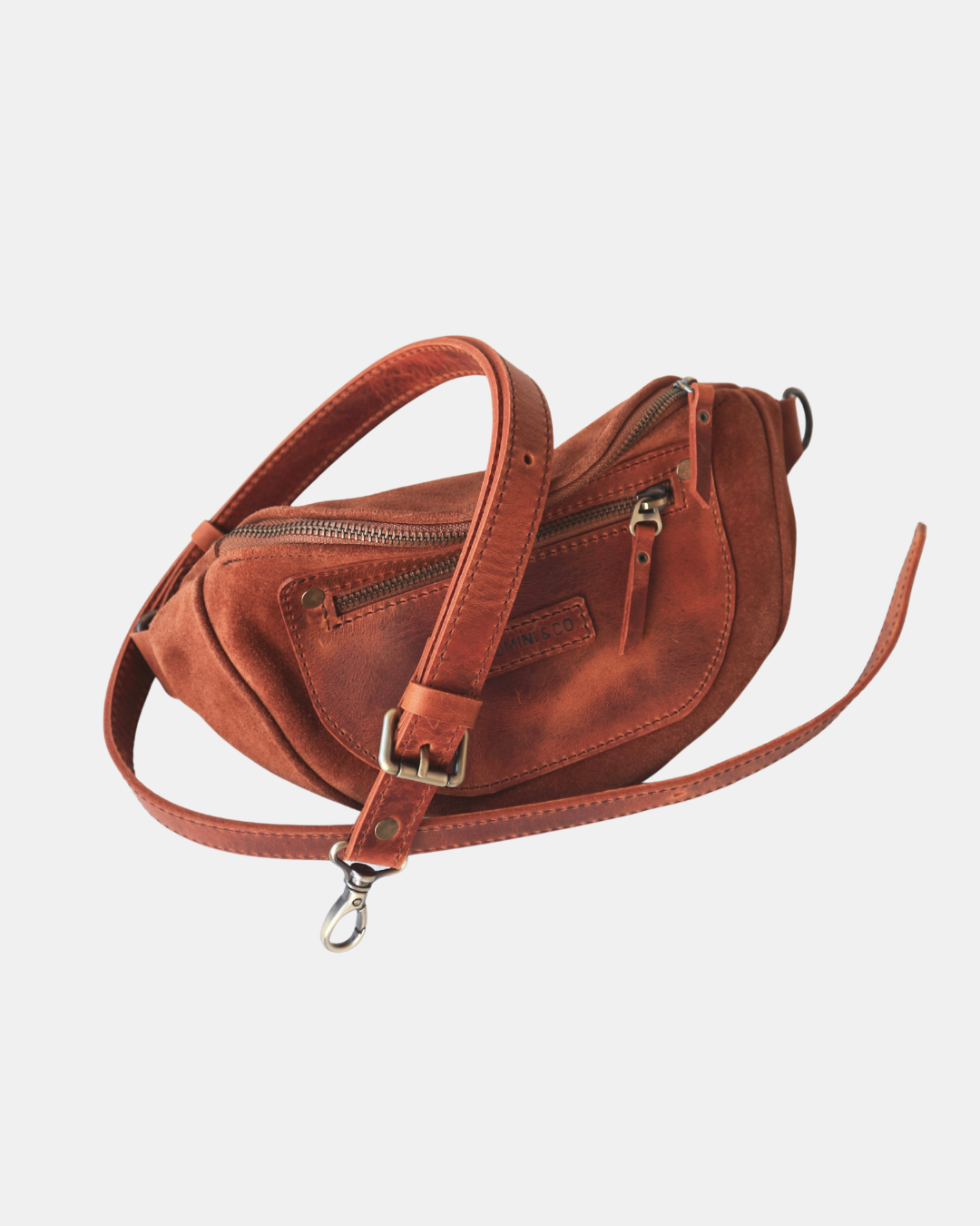 Brown leather handbag with a strap on a light gray background
