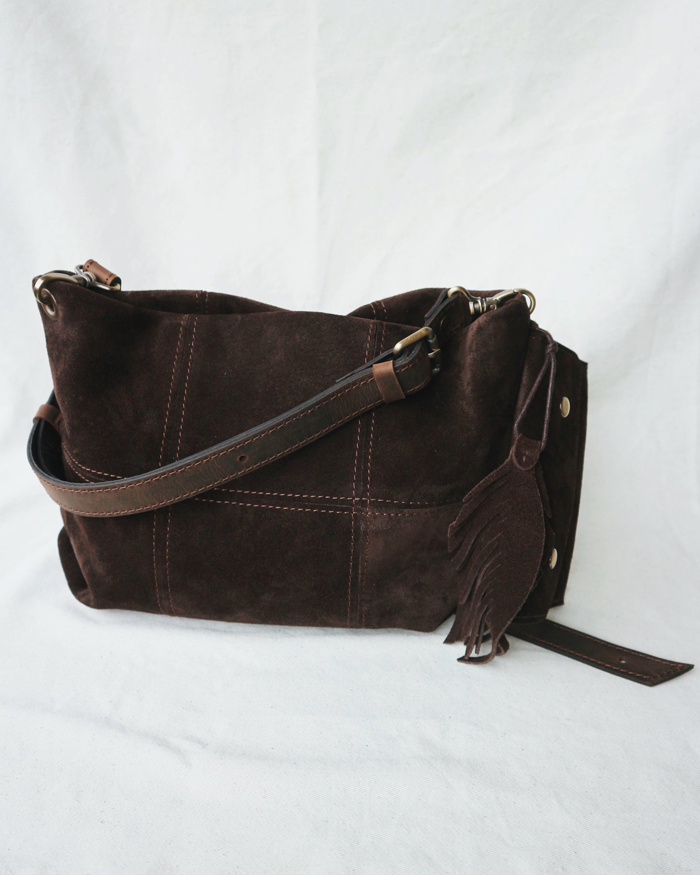 Brown leather handbag with a strap and charm for keys