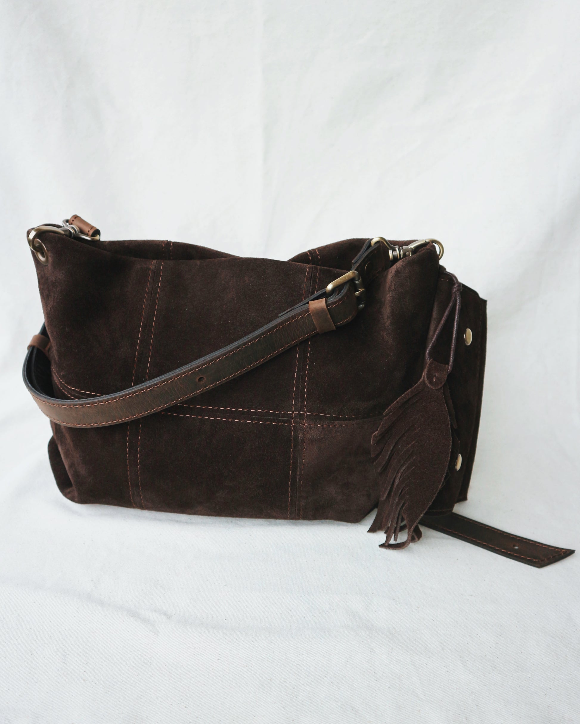 Brown leather handbag with a strap and charm for keys