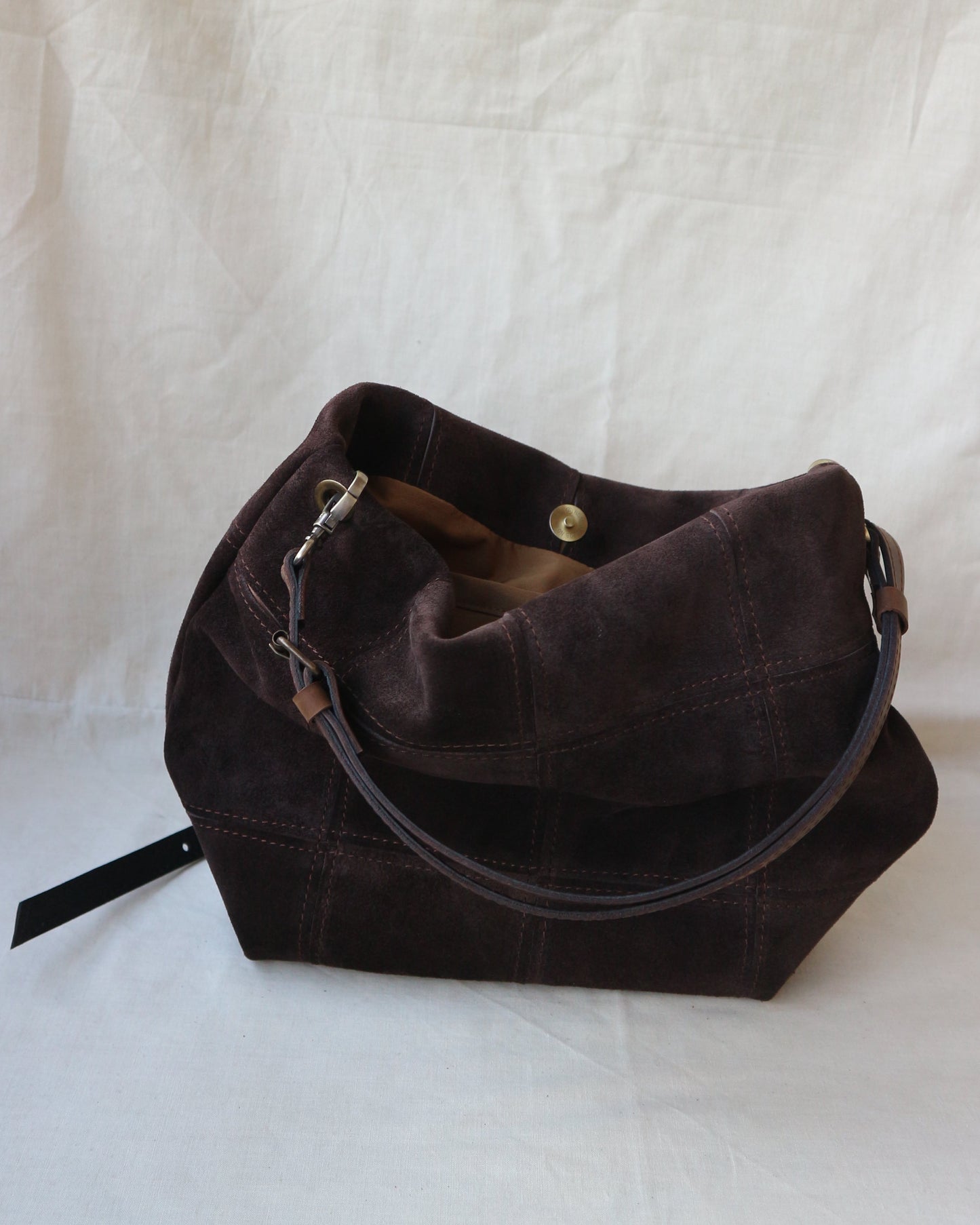 Brown leather bag on a white textured surface