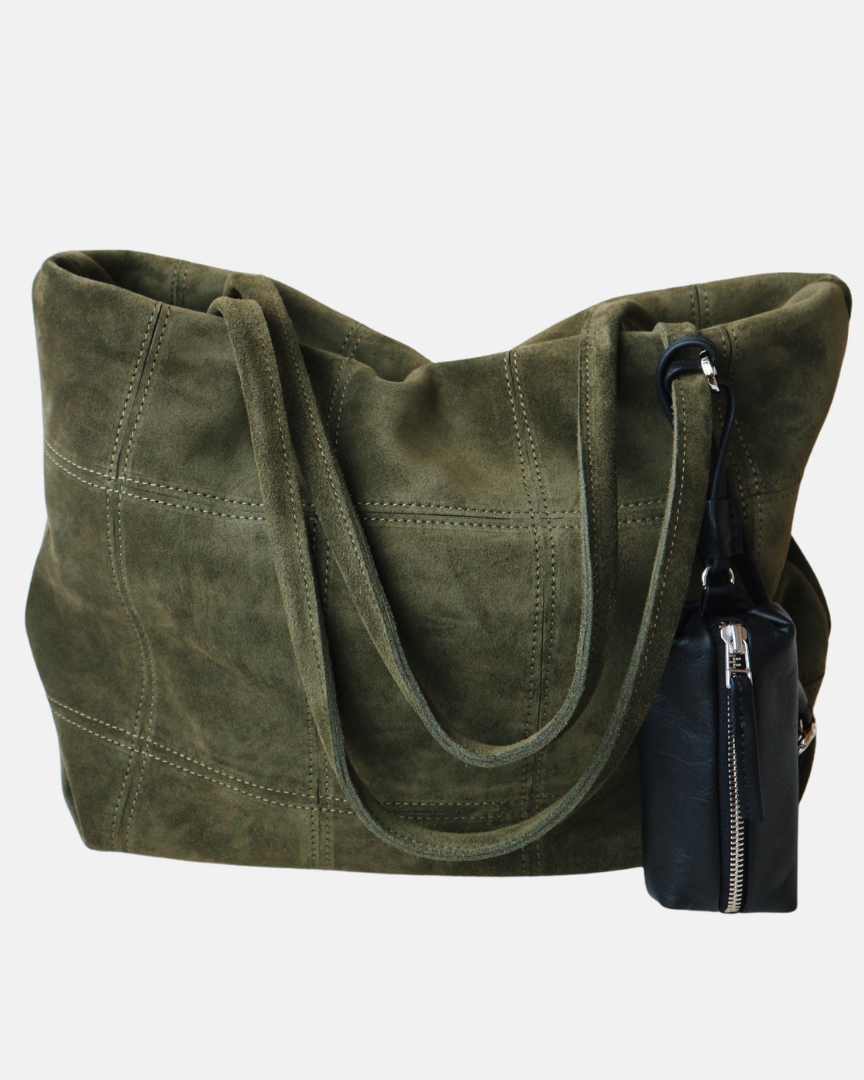 Green suede handbag with a smaller black bag attached on a white background