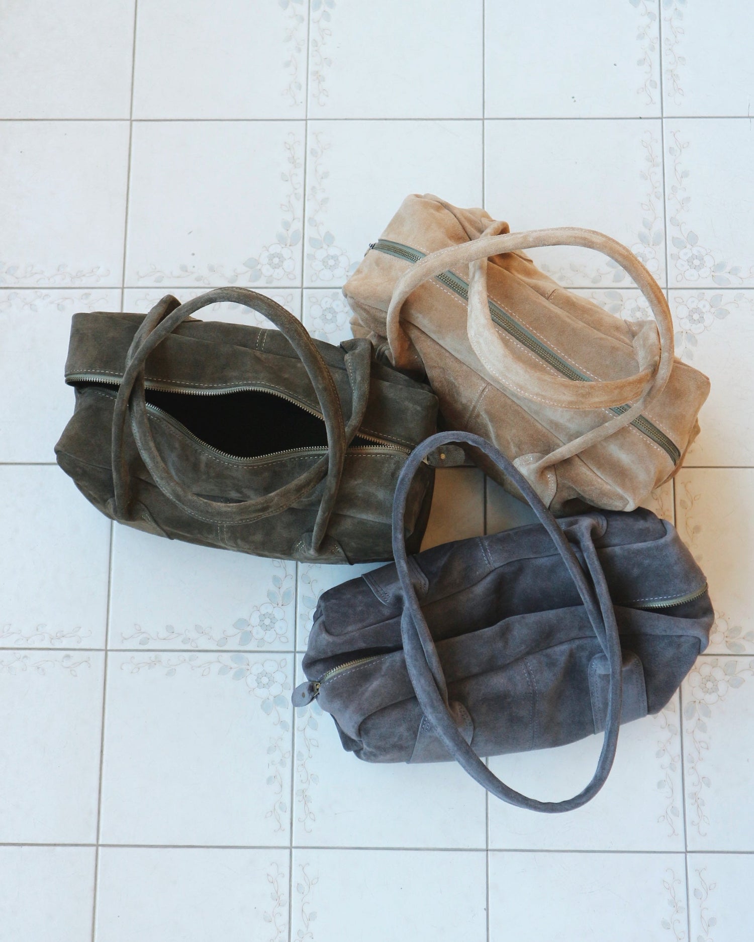 Pair of gray suede shoes on a tiled floor