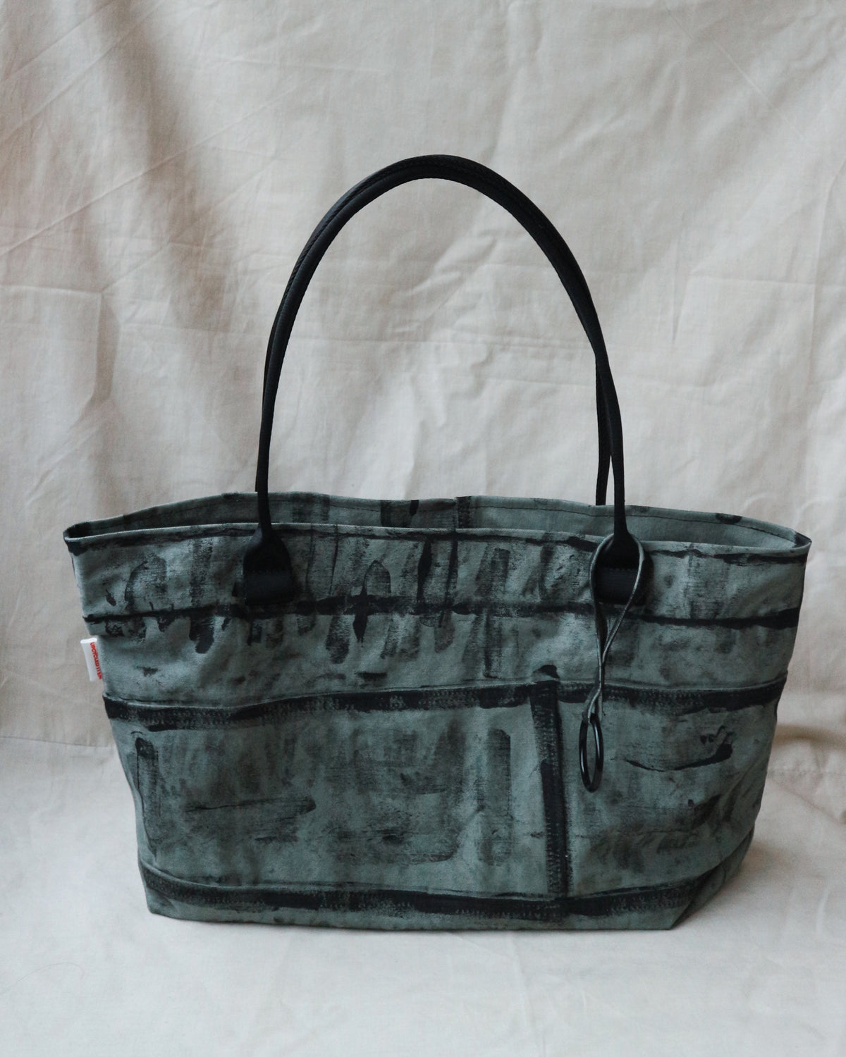 Green camouflage tote bag on a white fabric background