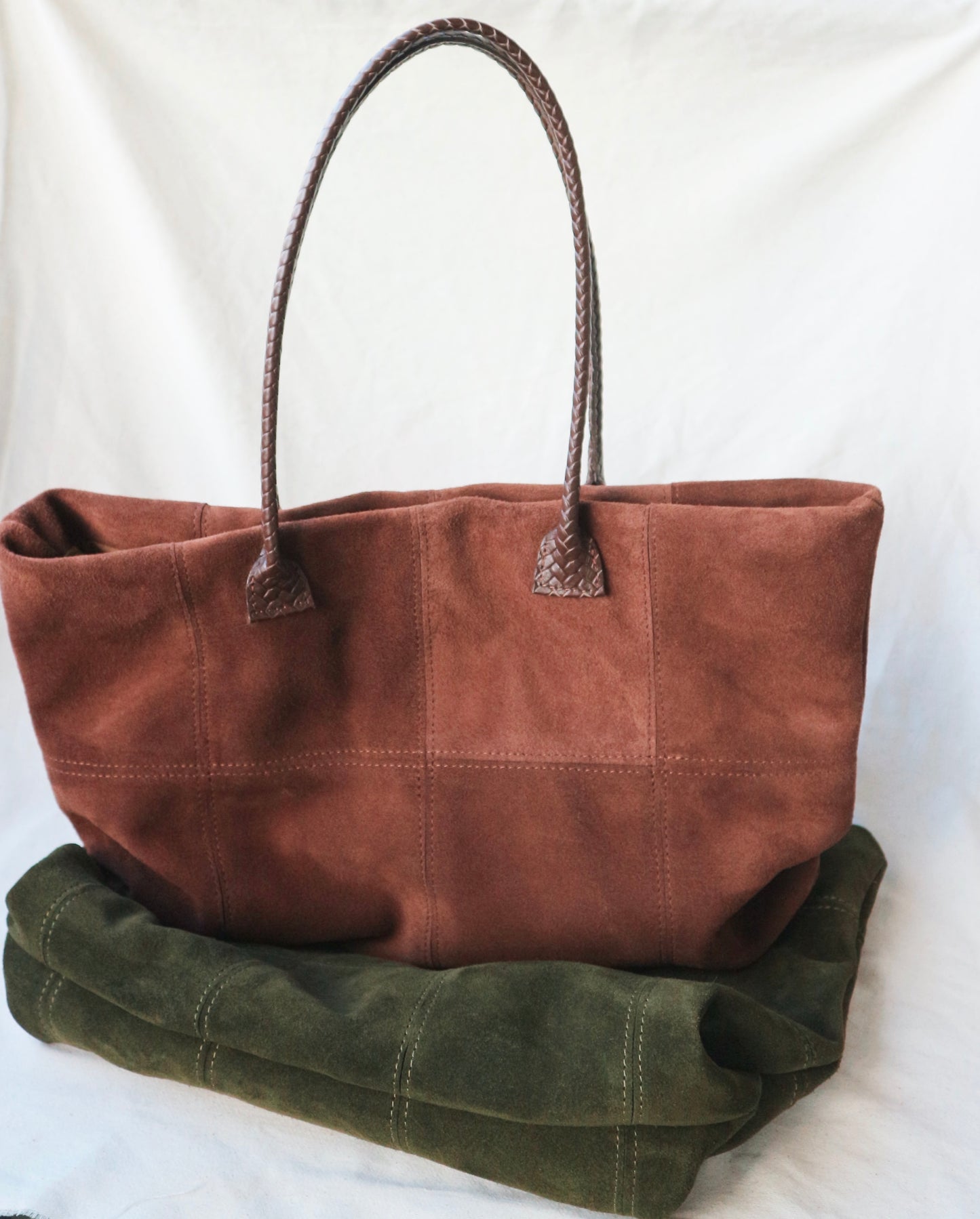Brown tote bag with a green fabric underneath on a white background