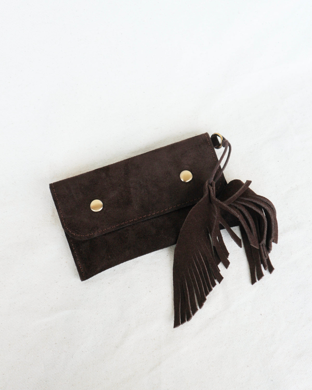 Brown suede clutch with tassels on a white background